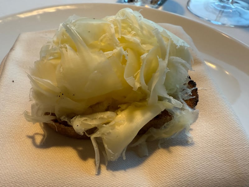 焼いたライ麦パンの上に薄く削った熟成ラクレットを重ねたもの
