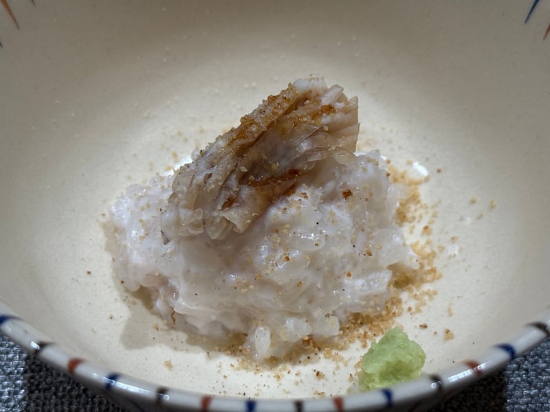 染付の鉢に白子のリゾットを盛り、炙ったまふぐをのせて唐墨を削りかけ、わさびを添えたもの