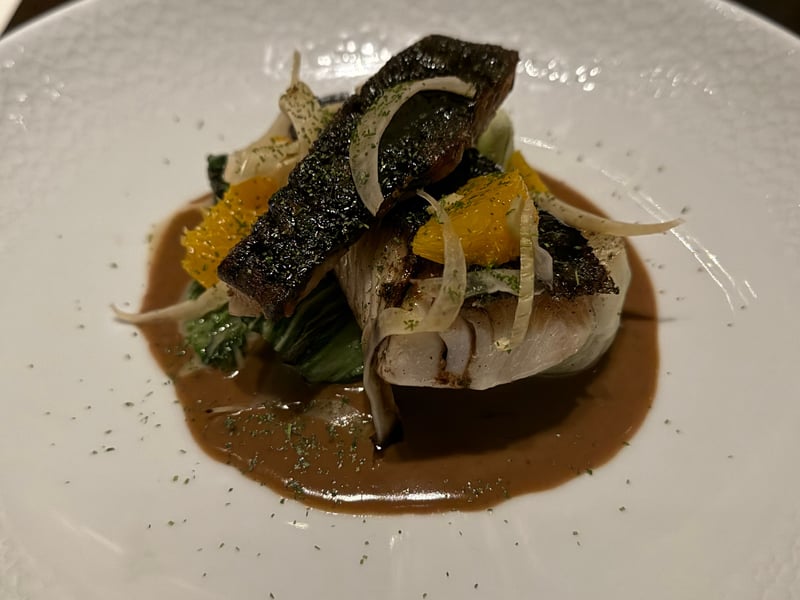 皮を焦がすまで焼いた銀鱈。チンゲン菜、削ったフェンネル、オレンジの果肉、褐色のソース