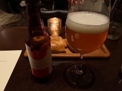 Moody Tongue のジュースト・ライチ IPA。瓶とワイングラス、奥にパン