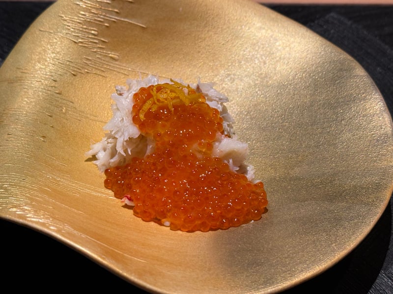 金色の皿に、ほぐした毛蟹の身といくら、刻んだ柚子の皮をのせた蒸し寿司