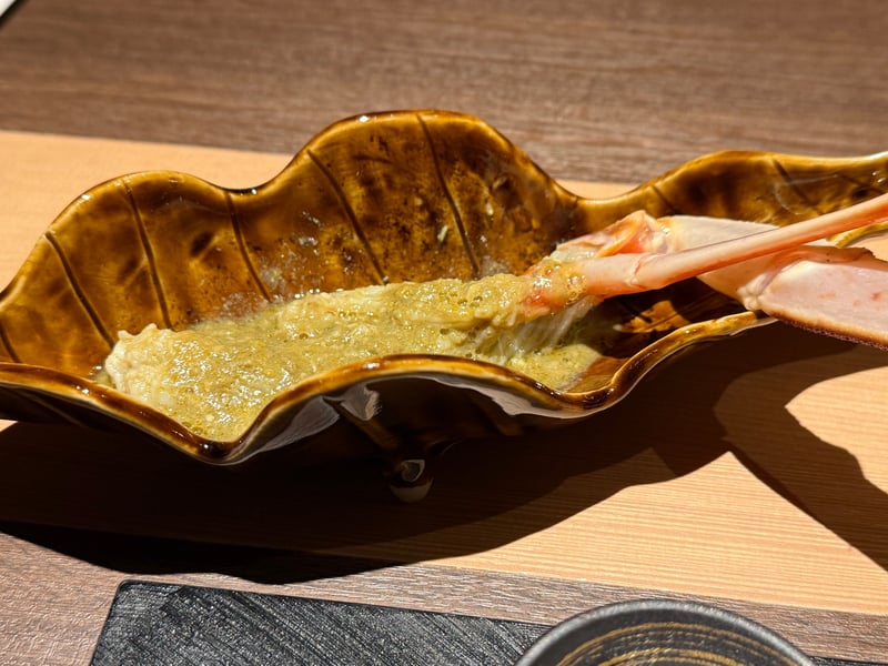 飴釉の木の葉形の器に蟹味噌。縁に蟹の脚の身がのる