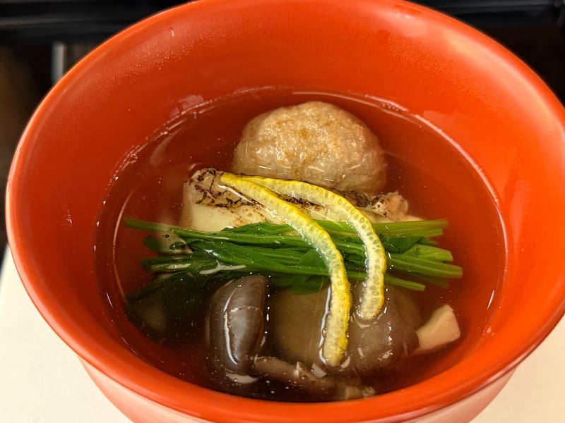 朱の椀に炙った鯛と蓮餅。青菜ときのこ、柚子の皮を渡す
