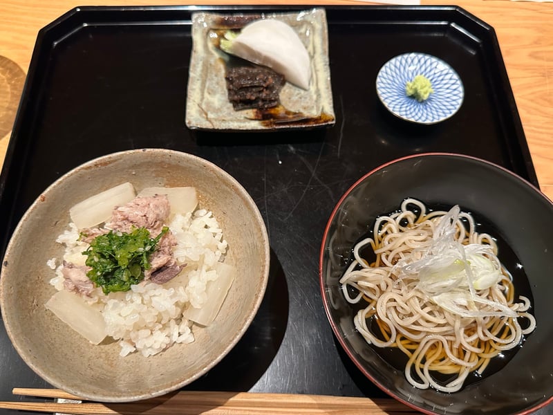 ぶり大根飯の膳。大根とほぐしたぶり、青菜をのせた飯に、香の物と蕎麦が並ぶ