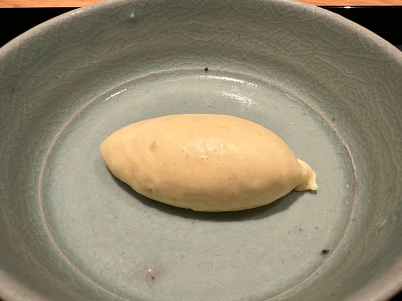 粉引の鉢に、焼いた橙色の果実と白いアイス