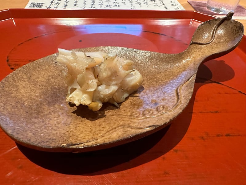 魚の形をした器に、藁で焼いたバイ貝の身