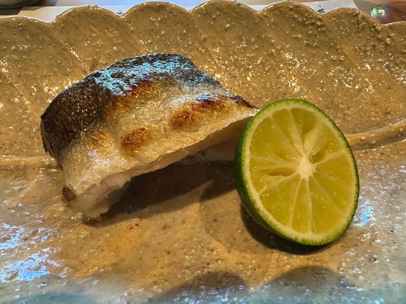 土の皿に、かますの炭火焼きと酢橘