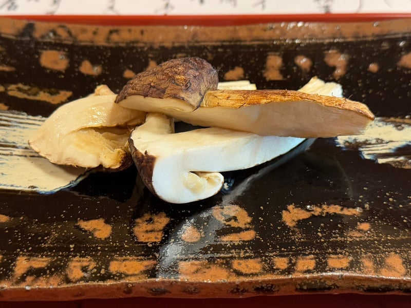 黒い長皿に、炭火で焼いた松茸と蒸した松茸