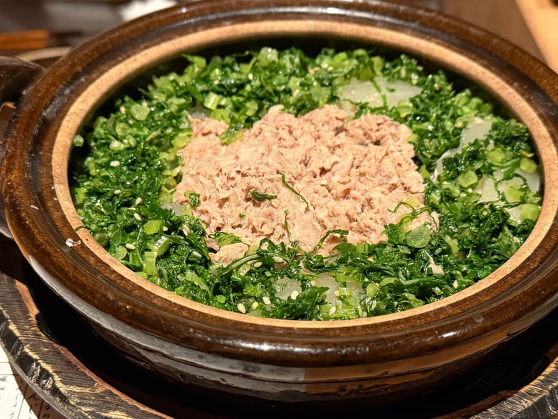 土鍋に、大根と刻んだ青菜を敷いた御飯の上にほぐしたぶり