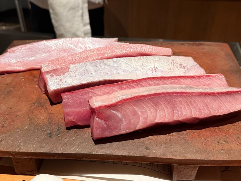 まな板に並んだ天然ぶりの柵。皮目と脂の白い層が見える