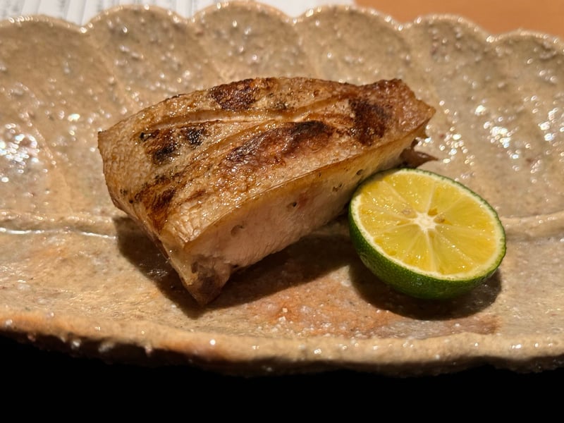 粉引の輪花皿に、皮目を焼いたぶりの切身と半割りの酢橘