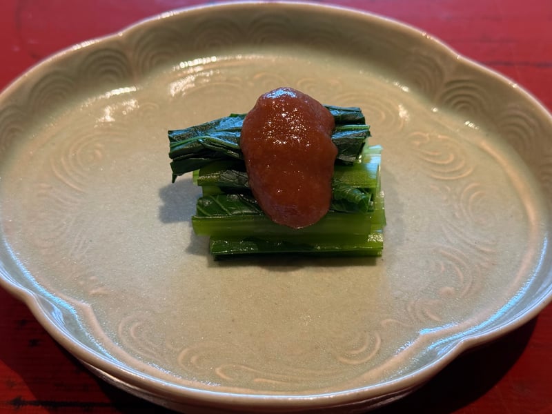白い輪花皿に、束ねた小松菜と梅肉