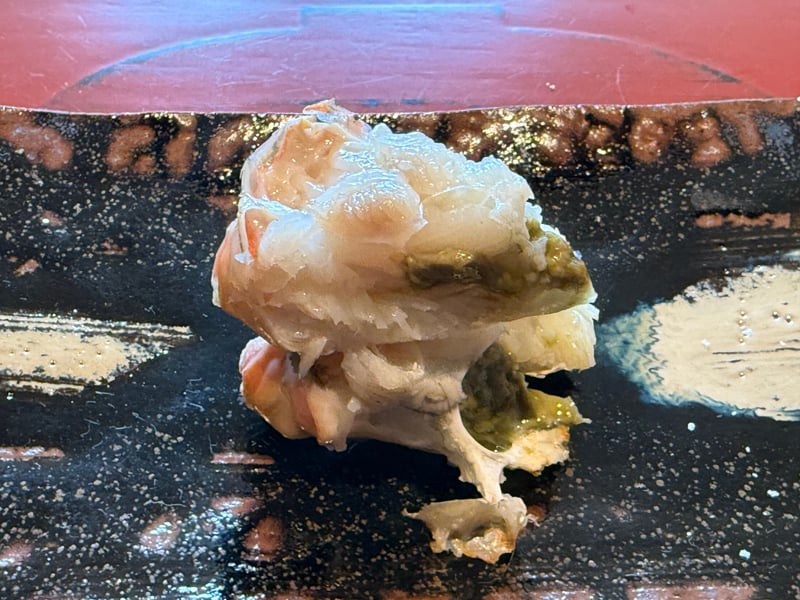 黒の器に、炭で焼いたズワイガニの身と蟹味噌