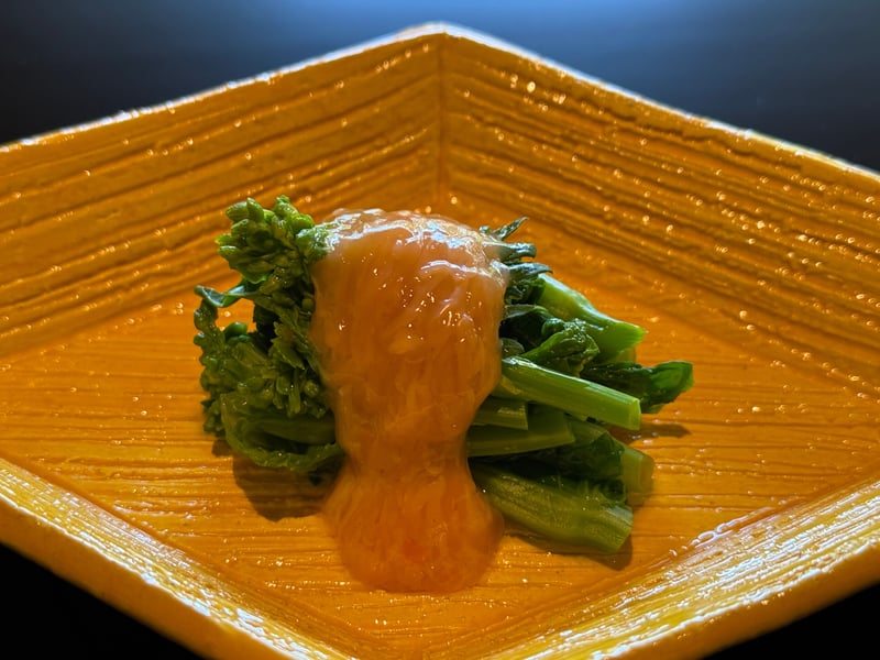 黄色い角皿に、菜の花の上へ生このこをのせ、生姜酢をかけた一品