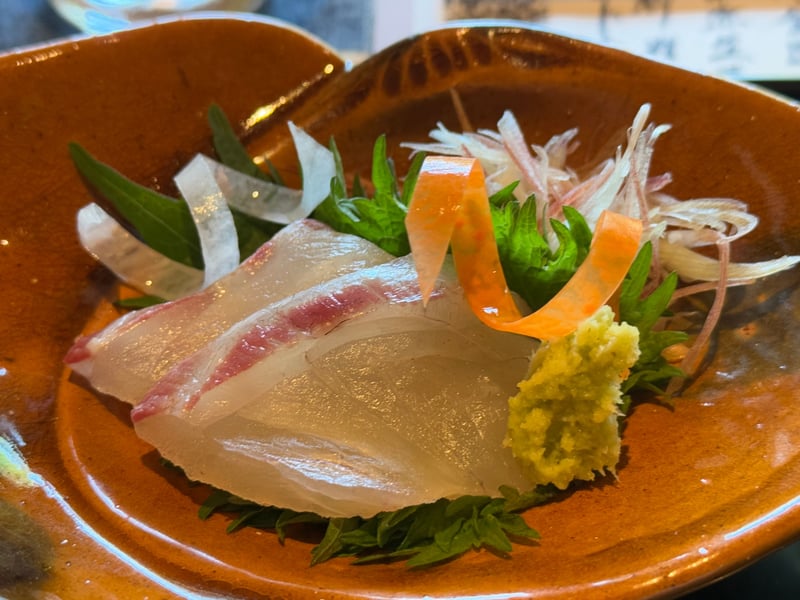 飴釉の鉢に黒鯛の造り。大葉、茗荷、大根、人参のあしらいと山葵