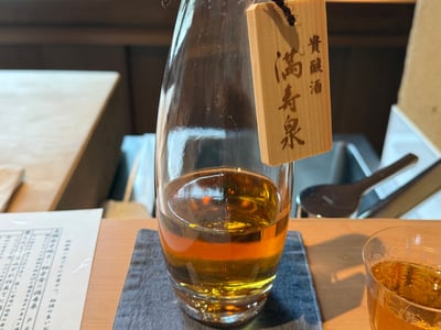 貴醸酒と木札の下がったガラスの片口。琥珀色の酒が入る