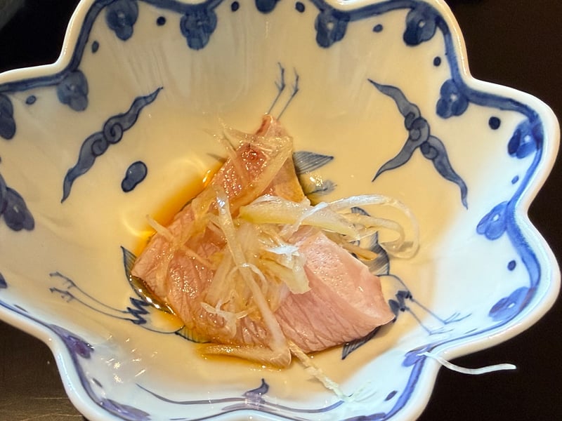染付の鉢に入ったぶりの砂ずりのしゃぶしゃぶ。玉ねぎの薄切りが重なる