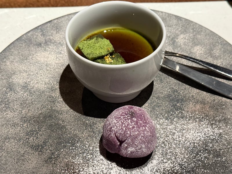 白いカップのプリンに抹茶をまぶした四角と金箔。皿には粉をふった紫色の大福が一つ