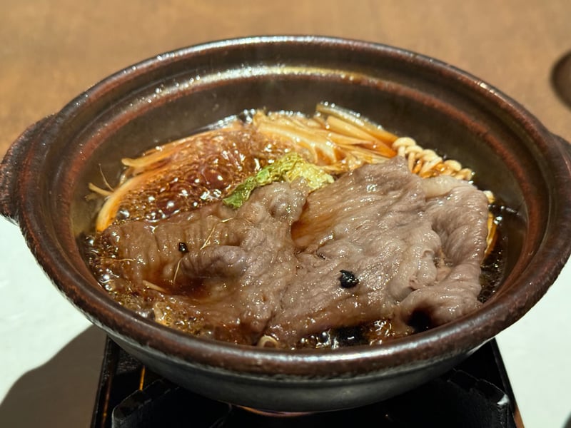 コンロにかけた土鍋で煮える五島牛の薄切り、えのきと舞茸、青菜