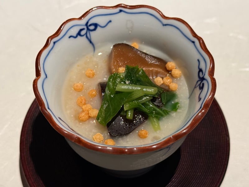 白い摺り流しを張った小さな椀に、冬菇と青菜、玄米のあられが浮く