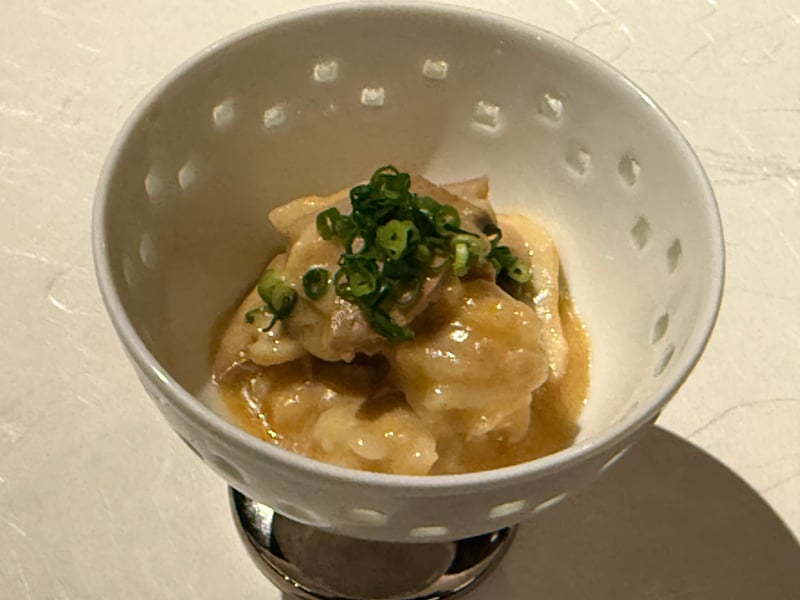 ガラスの脚付きの器に、酢味噌で和えた九絵の肝と身。青ねぎを散らす