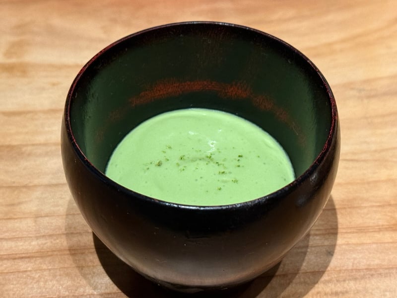 黒い漆の器に入った、淡い緑のスナップえんどうのムース