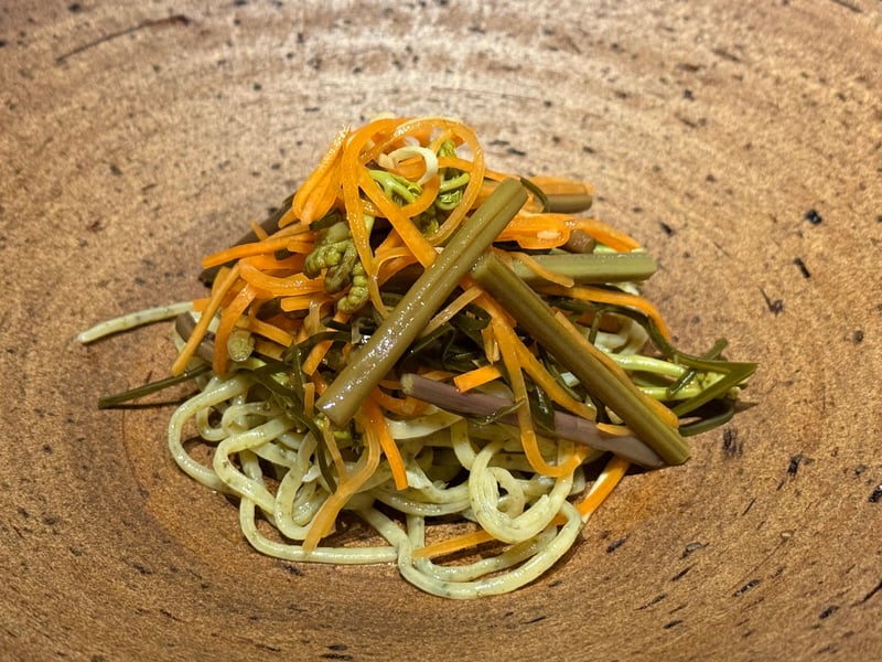 木の器に盛った蕨麺。わらびの茎と千切りの人参がのっている