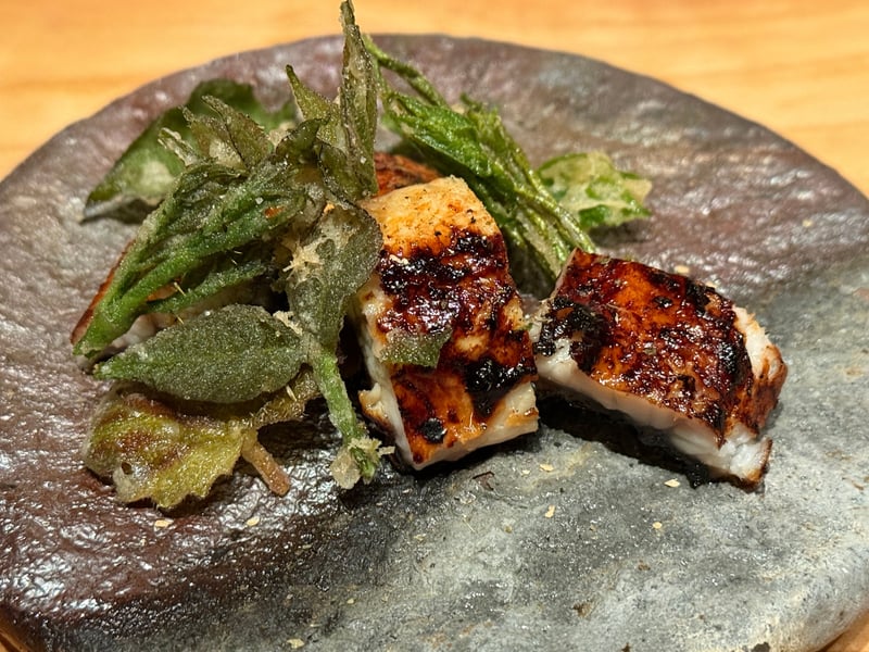 焦げ目のついた河口湖の鰻の炭火焼き二切れと、山菜の天ぷら
