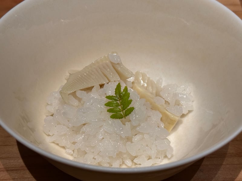 白い椀に盛った御飯と、筍のスライス、山椒の葉
