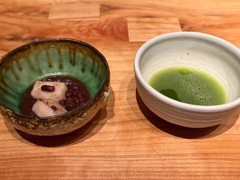 緑釉の鉢に入った小豆と焼いた餅、隣に抹茶を点てた茶碗