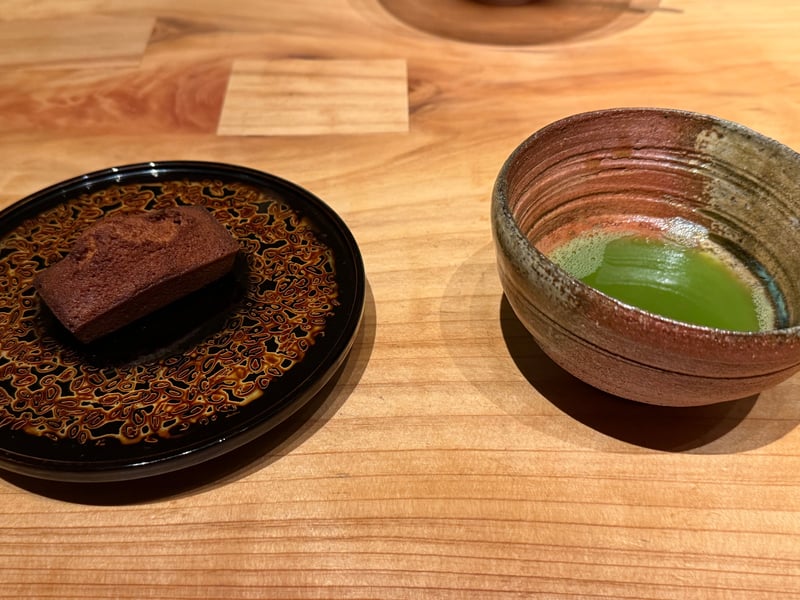 黒い漆の皿にのせた焼き菓子と、点てた抹茶の碗