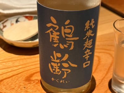 鶴齢 純米超辛口の瓶と、横に置かれたグラス