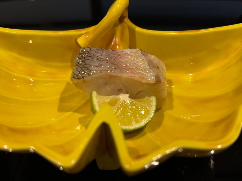 銀杏の葉をかたどった黄の皿に、皮つきの甘鯛一切れと酢橘