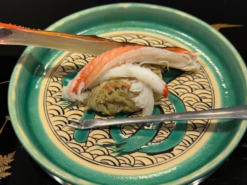 青海波の鉢に、蟹味噌の上へずわい蟹の身をのせて、殻と蟹用のフォークを添えて