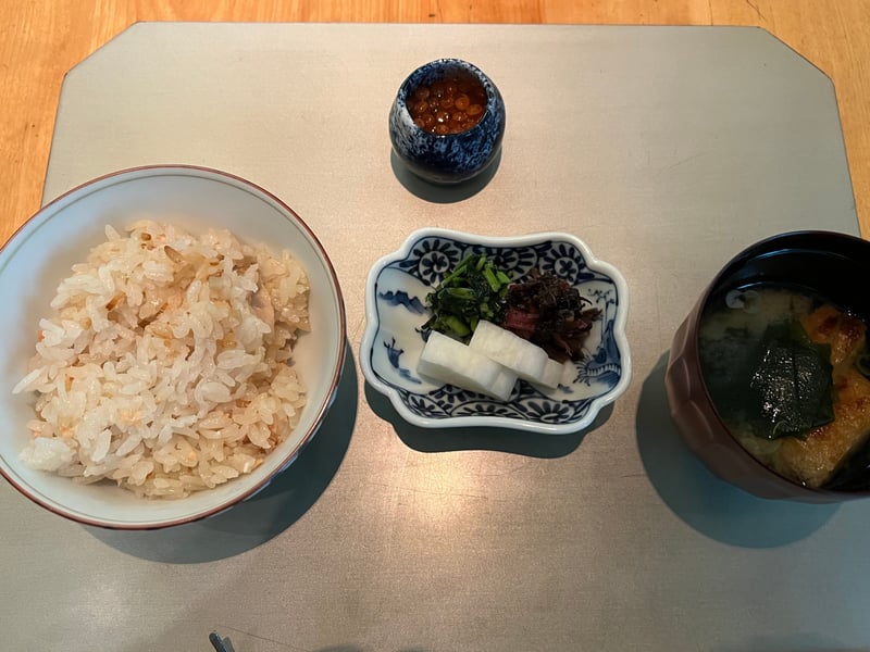 御食事の膳。秋鮭の炊き込みご飯、いくらの小壺、香の物、わかめの味噌椀が並ぶ