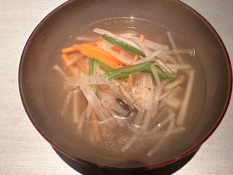 沢煮椀。細切りの牛蒡、大根、人参、いんげんに黒胡椒、底に穴子と京赤地どり