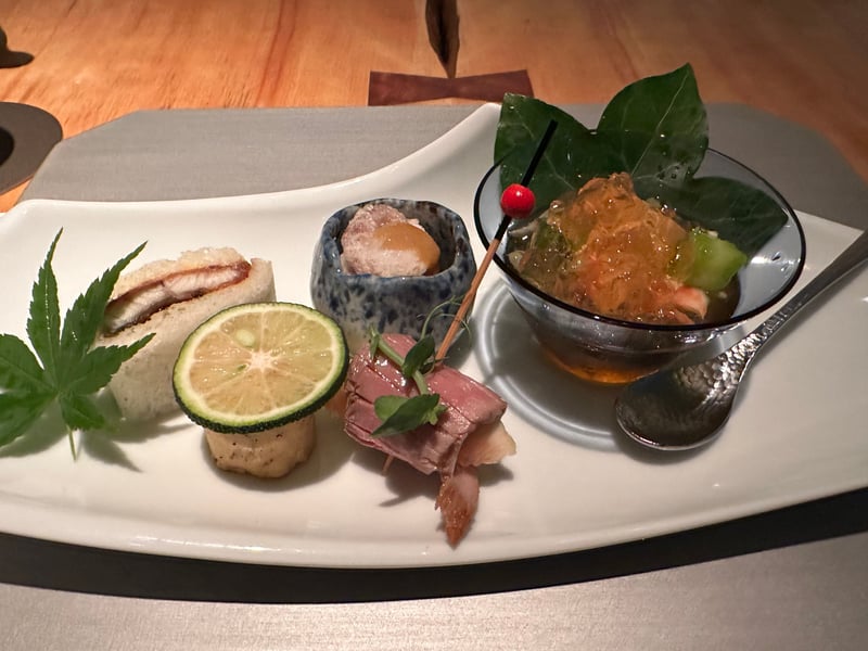 前菜の盛り合わせ。鰻サンド、酢橘をのせた鱧唐寿美、夏鴨の無花果巻き、小鉢の蛸唐揚げとこのわた、ガラスの器にじゅん菜と才巻海老の加減酢ジュレ