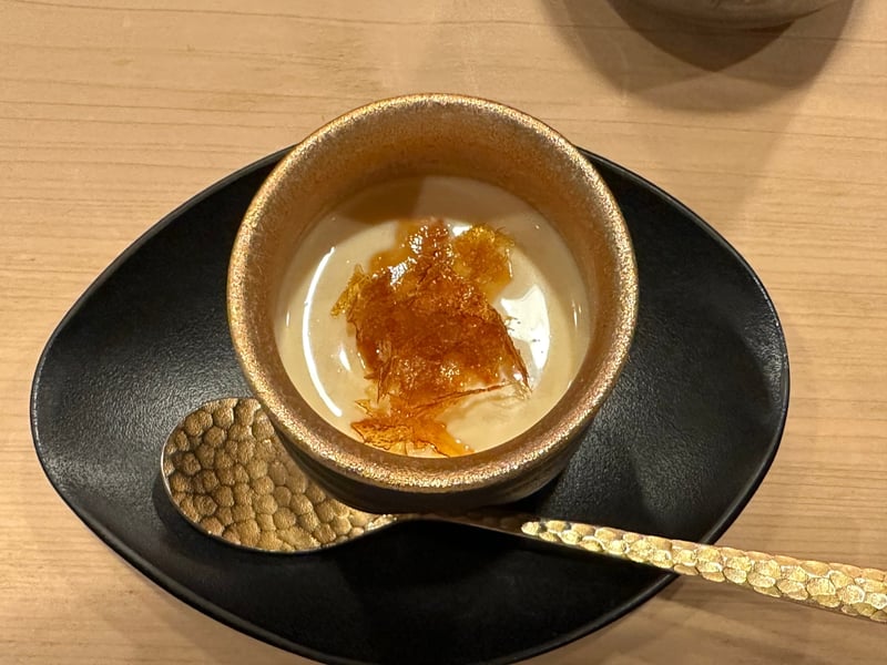 金色の器の塩プリン。上に割れたキャラメルが散らしてある