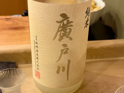 「廣戸川 純米」の一升瓶。手前のカウンターにグラス