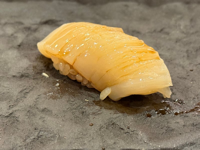 貝柱に包丁を入れて開き、かぶせたホタテの握り