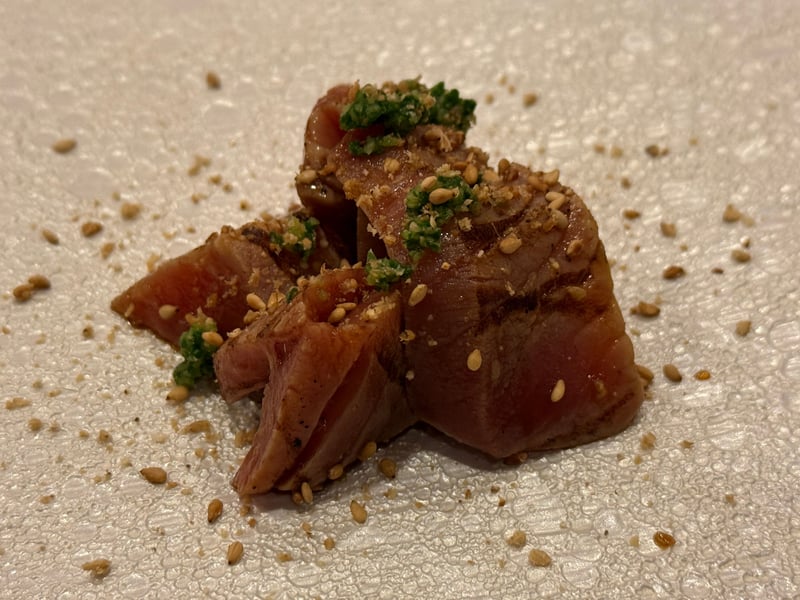 胡麻を散らし、緑の薬味をのせたメジマグロの漬け