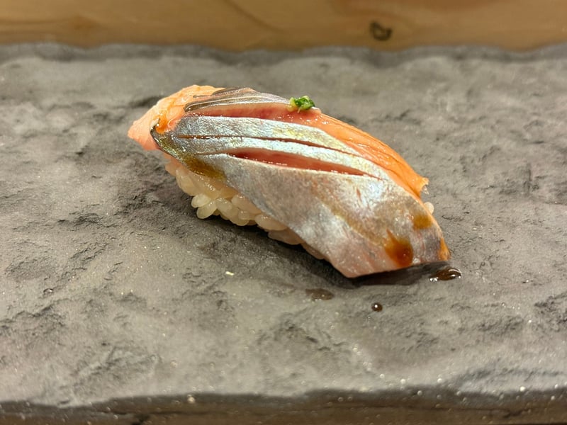 銀色の皮目を上にし、緑の薬味をのせたニシンの握り