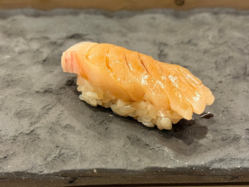 淡い色の身を重ねたサワラの握り