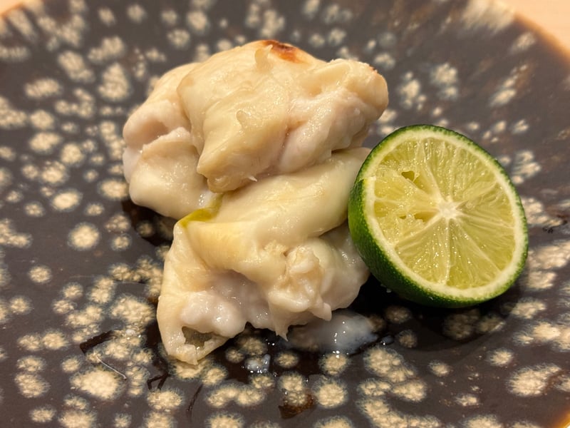 焼いた真鯛の白子と、半分に切った酢橘