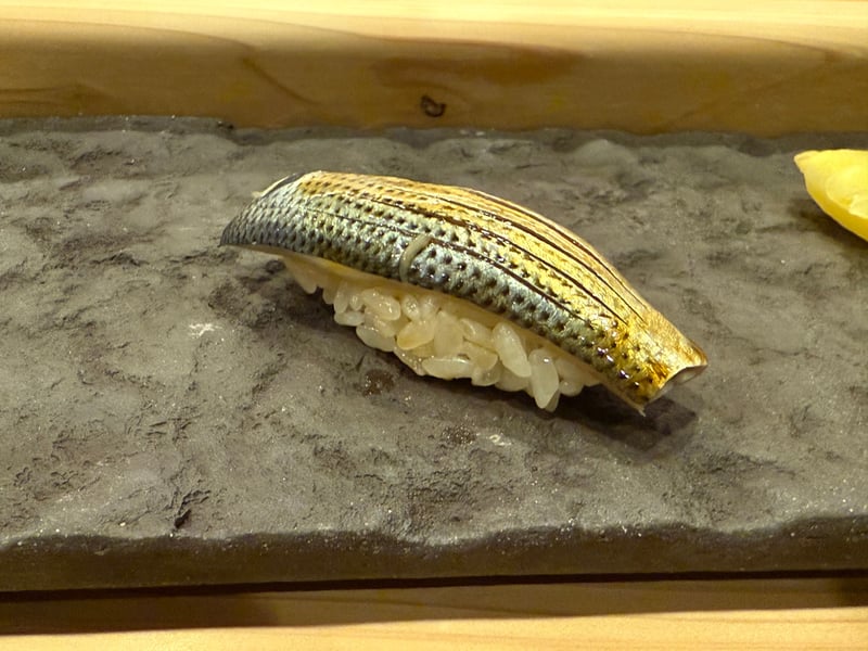 黒い石の板に、銀青の皮目に包丁目を入れたコハダの握り