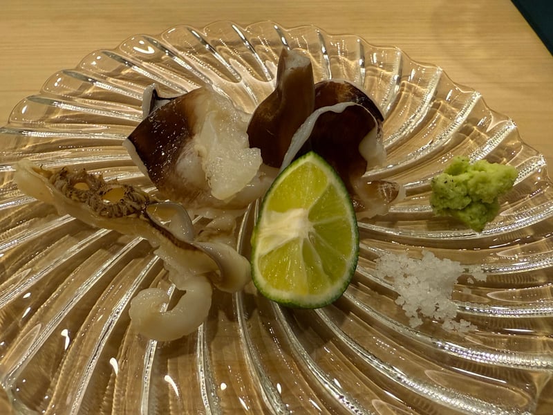 ガラスの皿に鳥貝の身と足、半分に切った酢橘、塩とわさび