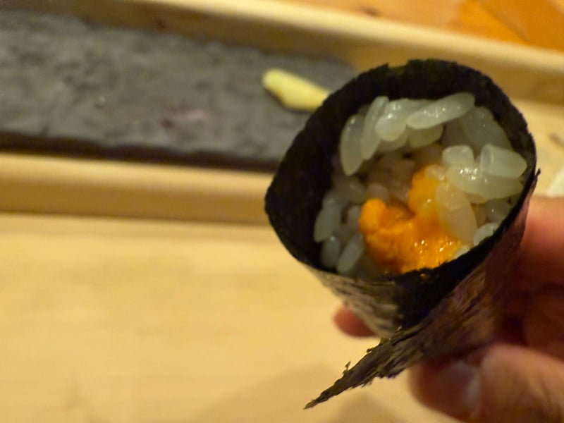 手に持った海苔の巻きの中に、シャリと雲丹が見えている