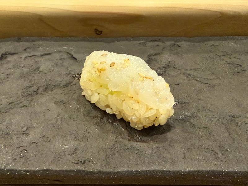 細かく包丁を入れた剣先イカの握りに、煎り胡麻