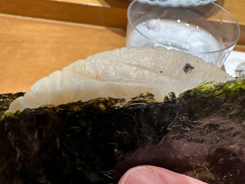海苔で巻いた平貝の磯部焼きを手で持つ