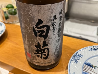 カウンターに置かれた奥能登の白菊 純米吟醸原酒の一升瓶